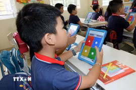 Học sinh trường Tiểu học Trần Nhân Tông (thành phố Nam Định) sử dụng thiết bị công nghệ để làm bài tập. (Ảnh: Nguyễn Lành/TTXVN)