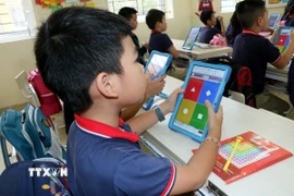 Học sinh trường Tiểu học Trần Nhân Tông (thành phố Nam Định) sử dụng thiết bị công nghệ để làm bài tập. (Ảnh: Nguyễn Lành/TTXVN)