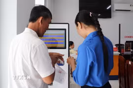 Đoàn viên xã Hỏa Lựu, thành phố Cần Thơ, hỗ trợ người dân tại Trung tâm phục vụ hành chính công. (Ảnh: Hồng Thái/TTXVN)
