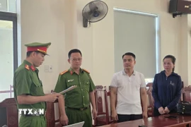 Thi hành Lệnh khởi tố bị can đối với Vũ Ngọc Liêm và Ngô Thị Tuyết. (Ảnh: TTXVN phát)