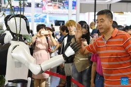 Một du khách tương tác với một chú robot tại Triển lãm sản phẩm tiêu dùng quốc tế Trung Quốc lần thứ 5 (CICPE) tại Hải Khẩu, tỉnh Hải Nam, miền Nam Trung Quốc. (Nguồn: Xinhua)