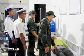 Các bác sỹ thăm khám cho bệnh nhân Võ Tấn Nước. (Ảnh: TTXVN phát)