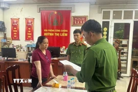 Cơ quan điều tra thi hành lệnh bắt đối với Huỳnh Thị Liêm. (Ảnh: TTXVN phát)