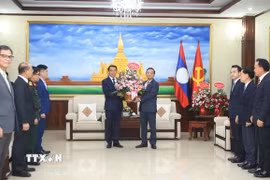 Đại sứ Nguyễn Minh Tâm chuyển lẵng hoa của Tổng Bí thư Việt Nam Tô Lâm chúc mừng 71 năm Ngày thành lập Đảng Nhân dân Cách mạng Lào. (Ảnh: Xuân Tú/TTXVN)