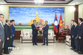 Đại sứ Nguyễn Minh Tâm chuyển lẵng hoa của Tổng Bí thư Việt Nam Tô Lâm chúc mừng 71 năm Ngày thành lập Đảng Nhân dân Cách mạng Lào. (Ảnh: Xuân Tú/TTXVN)