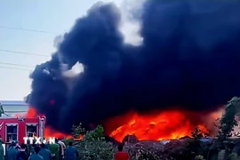 Lửa bùng phát dữ dội tại nhà xưởng bông của Chi nhánh Công ty Trách nhiệm hữu hạn Thương phẩm Á Phi (khu Hợp Thành, phường Yên Tử). (Ảnh: TTXVN phát)