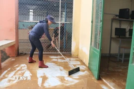 Dọn dẹp sau lũ. (Ảnh: Lê Xuân/TTXVN)