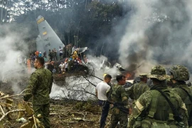 Các binh sĩ quân đội và người dân vây quanh chiếc máy bay gặp nạn. (Nguồn: AFP)