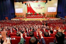 Các đại biểu biểu quyết, thông qua Nghị quyết Đại hội XIII Đảng Cộng sản Việt Nam. (Ảnh: TTXVN)