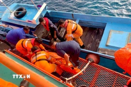 Lực lượng cứu hộ chuyển thi thể nạn nhân trong vụ cháy phà ngoài khơi đảo Sulawesi, Indonesia. (Ảnh: THX/TTXVN)