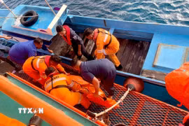 Lực lượng cứu hộ chuyển thi thể nạn nhân trong vụ cháy phà ngoài khơi đảo Sulawesi, Indonesia. (Ảnh: THX/TTXVN)