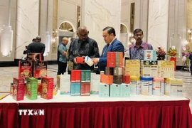Tham tán Thương mại Việt Nam tại Malaysia Lê Phú Cường (giữa) giới thiệu với khách mời các sản phẩm truyền thống của Việt Nam. (Ảnh: Thành Trung/TTXVN)
