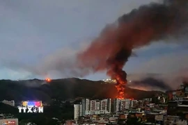 Khói lửa bốc lên tại khu phức hợp quân sự Fuerte Tiuna lớn nhất Venezuela, sau một loạt tiếng nổ ở thủ đô Caracas ngày 3/1. (Ảnh: France24/TTXVN)