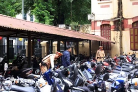 Lực lượng chức năng phối hợp với Ban Giám hiệu các trường tiến hành kiểm tra khu vực bãi gửi xe trong trường THPT Trần Phú-Hoàn Kiếm (Hà Nội). (Ảnh: Tuấn Anh/TTXVN)