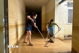 Người dân phường Phan Đình Phùng, thành phố Thái Nguyên dọn vệ sinh nhà cửa ngay khi nước lũ rút. (Ảnh: Hoàng Nguyên/TTXVN)