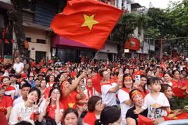 Người dân vui mừng chào đón đoàn diễu binh, diễu hành đi qua. (Ảnh: TTXVN)