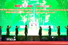 Các đại biểu hai nước Việt Nam-Lào nhấn nút khai mạc Hội chợ. (Ảnh: Xuân Tú/TTXVN)