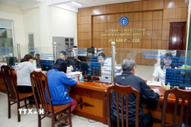 Nhân viên Bảo hiểm Xã hội tỉnh Hưng Yên hướng dẫn người dân làm thủ tục tham gia Bảo hiểm xã hội. (Ảnh: Phạm Kiên/TTXVN)