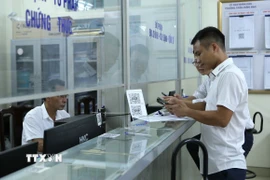Người dân đến làm thủ tục, giấy tờ tại Bộ phận tiếp nhận và trả kết quả phường Trần Hưng Đạo, thành phố Nam Định. (Ảnh: Công Luật/TTXVN)