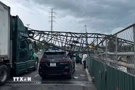 Cần cẩu thi công đè trúng hai xe ôtô trên cầu vượt Mỹ Thủy, thành phố Thủ Đức. (Ảnh: TTXVN phát)
