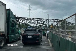 Cần cẩu thi công đè trúng hai xe ôtô trên cầu vượt Mỹ Thủy, thành phố Thủ Đức. (Ảnh: TTXVN phát)