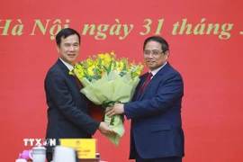 Thủ tướng Phạm Minh Chính tặng hoa chúc mừng ông Bùi Thế Duy giữ chức Giám đốc Đại học Quốc gia Hà Nội. (Ảnh: Dương Giang/TTXVN)