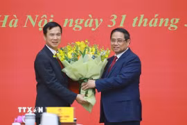 Thủ tướng Phạm Minh Chính tặng hoa chúc mừng ông Bùi Thế Duy giữ chức Giám đốc Đại học Quốc gia Hà Nội. (Ảnh: Dương Giang/TTXVN)