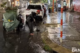 Công nhân dọn vệ sinh trên đường phố và khơi thông thoát nước sau khi nước rút vào rạng sáng 12/6. (Nguồn: Báo Đà Nẵng)
