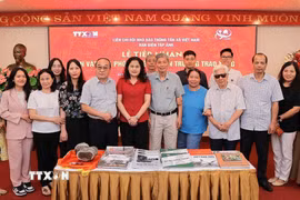 Bà Nguyễn Thị Sự, Ủy viên Ban Thường vụ Đảng ủy, Phó Tổng giám đốc TTXVN, chụp ảnh lưu niệm cùng Phóng viên lão thành và thân nhân của người trao tặng hiện vật. (Ảnh: Lê Đông/TTXVN)