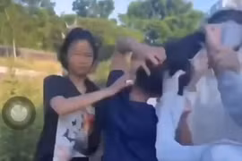 Nữ sinh (áo đen, thứ 2 từ trái sang) bị nhóm bạn túm tóc, liên tục đánh vào phần đầu. (Ảnh cắt từ video)