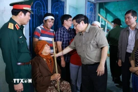 Thủ tướng Phạm Minh Chính thăm, động viên hộ gia đình bị thiệt hại nặng nề do mưa lũ tại thôn Phú Hữu, xã Hòa Thịnh. (Ảnh: Dương Giang/TTXVN)