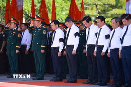 Thủ tướng Lê Minh Hưng và các đại biểu mặc niệm các liệt sỹ quân tình nguyện và chuyên gia Việt Nam. (Ảnh: Dương Giang/TTXVN)