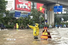 Công nhân làm nhiệm vụ thoát nước tại khu vực ngập sâu trên đường Nguyễn Trãi (Hà Nội). (Ảnh: Quốc Lũy/TTXVN)