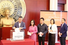 Đại sứ Việt Nam tại Trung Quốc Phạm Thanh Bình và các cán bộ Đại sứ quán tham gia quyên góp, ủng hộ đồng bào bị lũ lụt. (Ảnh: Công Tuyên/TTXVN)