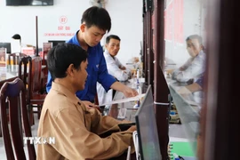 Đoàn viên xã Hỏa Lựu, Cần Thơ, hỗ trợ người dân tại Trung tâm phục vụ hành chính công. (Ảnh: Hồng Thái/TTXVN)