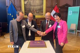 Giám đốc HUST Huỳnh Quyết Thắng và Hiệu trưởng BOKU Eva Schulev-Steindl thực hiện nghi thức kỷ niệm quan hệ hợp tác 25 năm giữa hai trường đại học. (Ảnh: TTXVN phát)