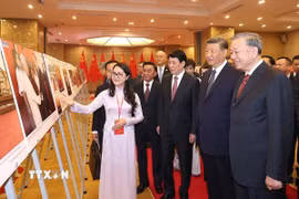 Tổng Bí thư Tô Lâm, Chủ tịch nước Lương Cường cùng Tổng Bí thư, Chủ tịch nước Trung Quốc Tập Cận Bình tham quan trưng bày ảnh. (Ảnh: Thống Nhất/TTXVN)