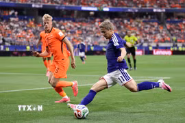 Tiền đạo Daizen Maeda (phải) của Nhật Bản tranh bóng với hậu vệ Hà Lan Jan Paul Van Hecke. (Ảnh: AFP/TTXVN)