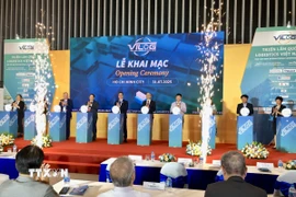 Đại biểu thực hiện nghi thức khai mạc triển lãm. (Ảnh: Mỹ Phương/TTXVN)