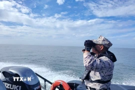 Lực lượng cứu hộ tìm kiếm nạn nhân trong vụ lật thuyền ở bang Kedah, Malaysia. (Ảnh: THX/TTXVN)