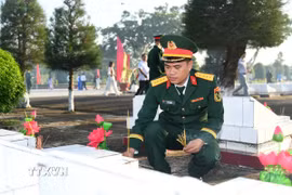 Cán bộ Bộ Chỉ huy Quân sự tỉnh An Giang thắp hương tại các phần mộ Liệt sỹ. (Ảnh: Văn Sỹ/TTXVN)