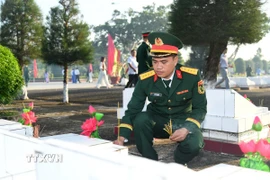 Cán bộ Bộ Chỉ huy Quân sự tỉnh An Giang thắp hương tại các phần mộ Liệt sỹ. (Ảnh: Văn Sỹ/TTXVN)