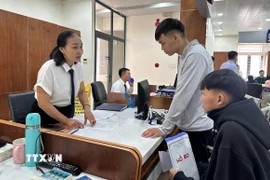 Cán bộ Trung tâm hành chính công phường Tam Kỳ, thành phố Đà Nẵng, hướng dẫn người dân làm thủ tục hành chính. (Ảnh: Trần Tĩnh/TTXVN)