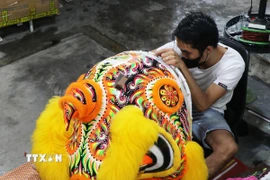 Anh Trương Như Rem, đường Trần Hưng Đạo, phường Phú Xuân, thành phố Huế đang hoàn thành một đầu lân lớn. (Ảnh: Nguyên Lý/TTXVN)