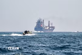 Tàu hàng neo ở ngoài khơi bán đảo Musandam, Oman, chờ qua eo biển Hormuz. (Ảnh: Getty Images/TTXVN)