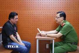 Đại tá Bùi Đức An, Phó Giám đốc Công an thành phố, Thủ trưởng Cơ quan Cảnh sát điều tra, trực tiếp lấy lời khai đối với một số đối tượng có liên quan. (Ảnh: TTXVN phát)