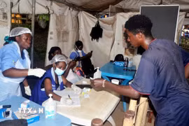 Nhân viên y tế lấy thông tin của hành khách nhập cảnh tại điểm kiểm soát biên giới Mpondwe, Uganda. (Ảnh: THX/TTXVN)