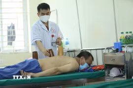 Sử dụng phương pháp giác hơi điều trị cho bệnh nhân. (Ảnh: Anh Tuấn/TTXVN)