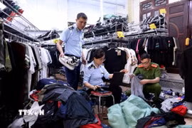 Lực lượng quản lý thị trường tỉnh Tuyên Quang kiểm tra, lập biên bản một cửa hàng kinh doanh quần áo có dấu hiệu giả mạo nhãn hiệu tại phường Minh Xuân, thành phố Tuyên Quang. (Ảnh: Quang Cường/TTXVN)