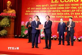 Thượng tướng Trịnh Văn Quyết (phải), Bí thư Trung ương Đảng, Chủ nhiệm Tổng cục Chính trị QĐND Việt Nam, trao Quyết định của Trung ương chỉ định chức danh Bí thư Tỉnh ủy Tuyên Quang (mới) cho ông Hầu A Lềnh. (Ảnh: Quang Cường/TTXVN)